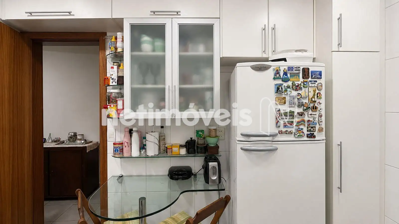 Cozinha com armários e mesa de apoio