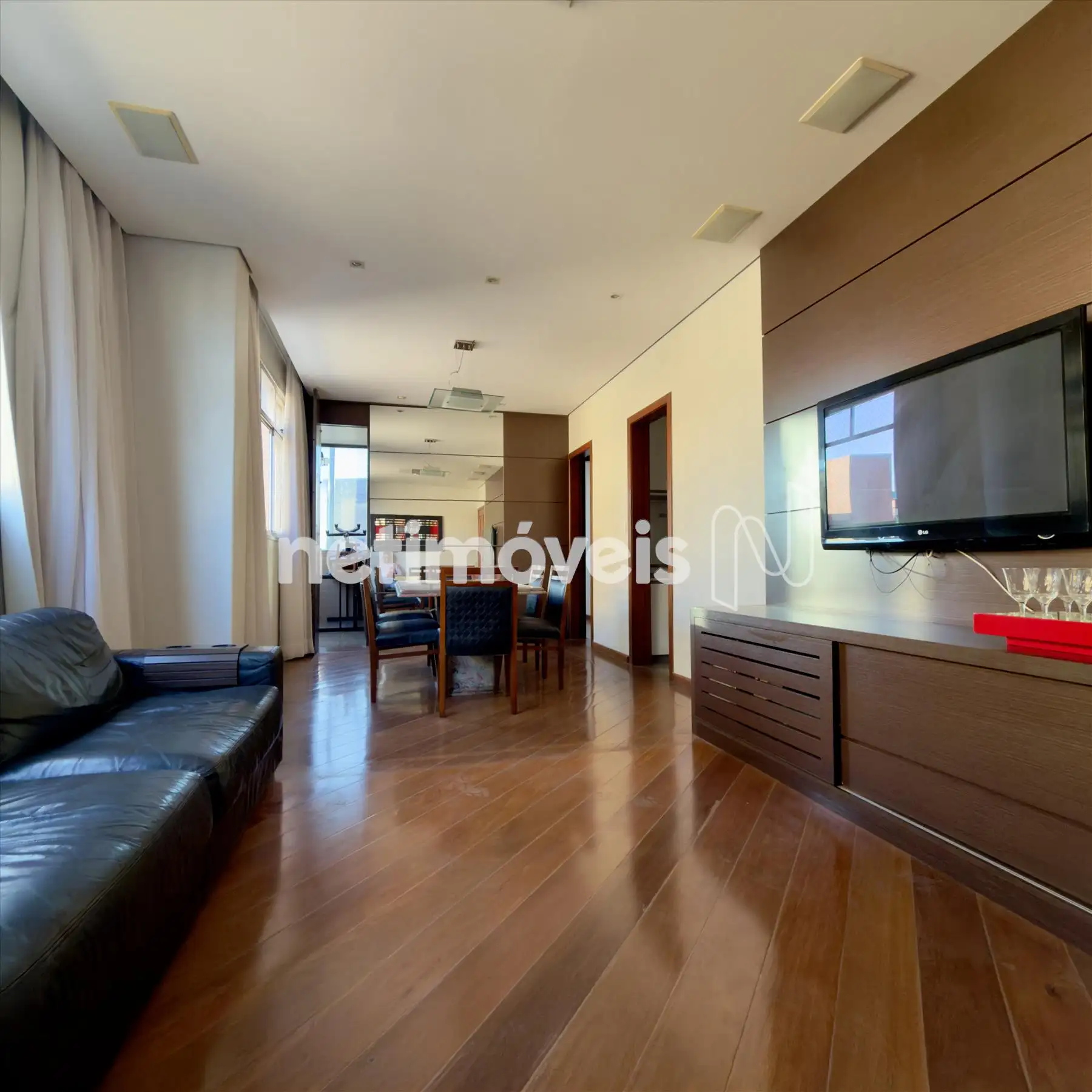 Sala de tv com painel de madeira