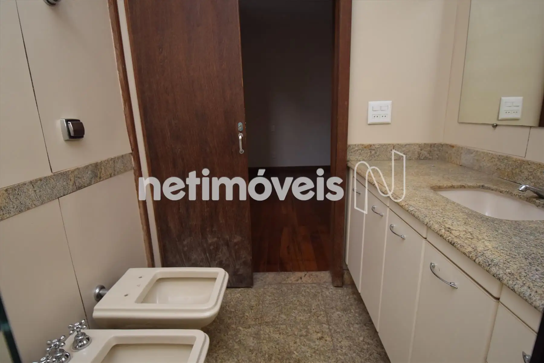 Banheiro suíte com bancada e piso em granito