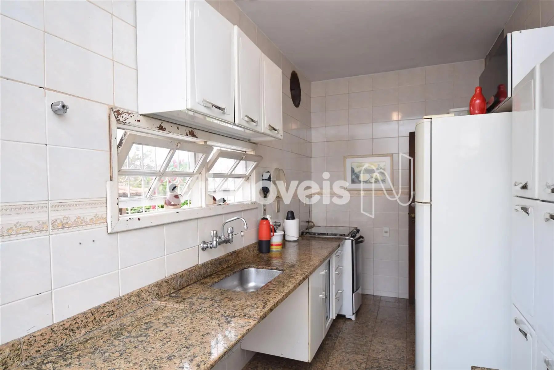 Cozinha com bancadas e piso em granito