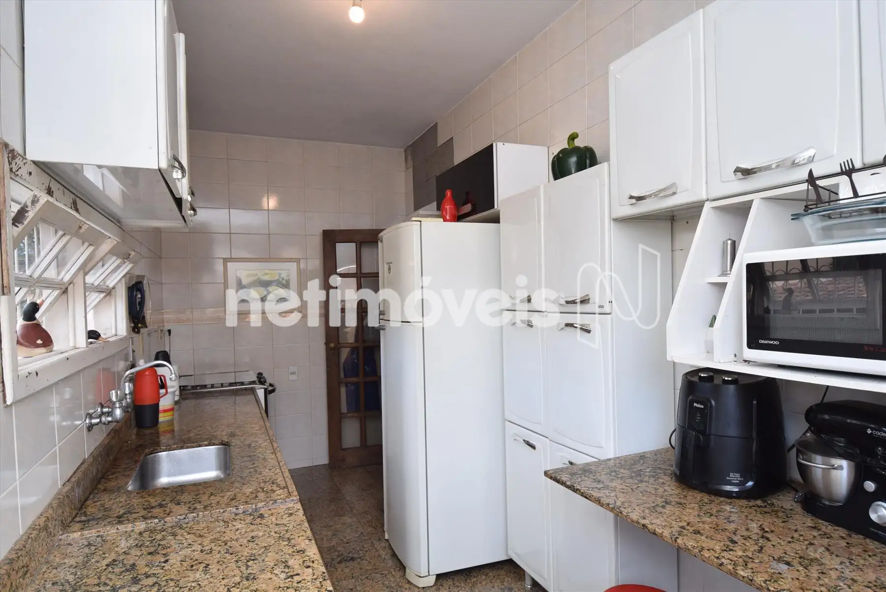 Cozinha com bancadas e piso em granito