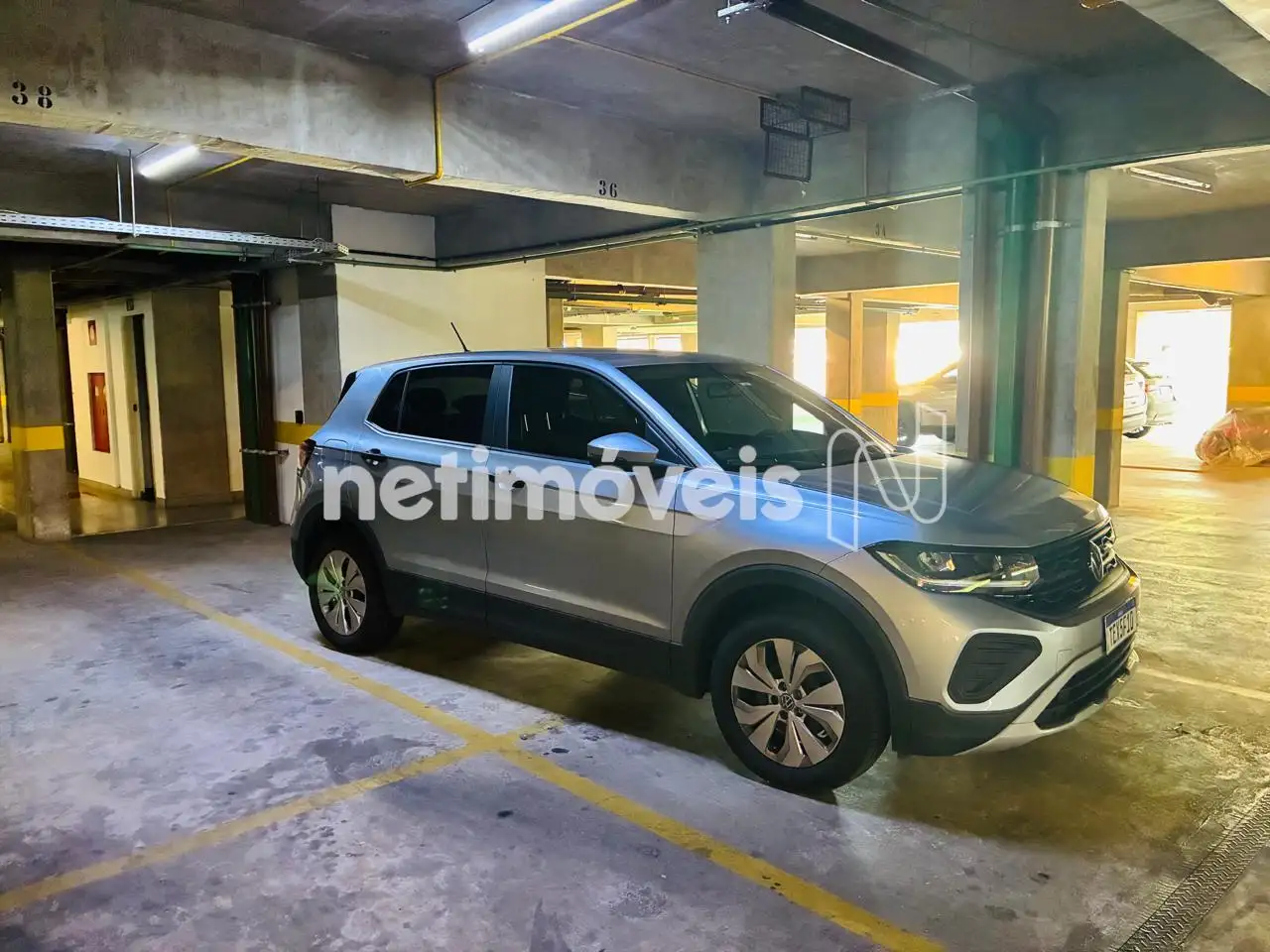 Duas vagas de garagem em linha, sob pilotis.