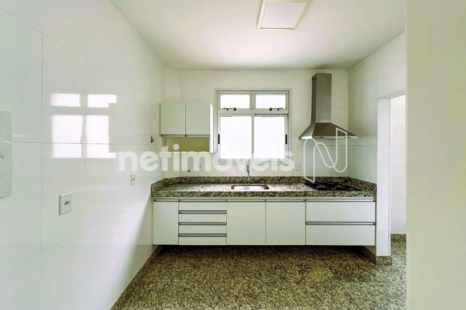 grande bancada em granito com coifa e cooktop