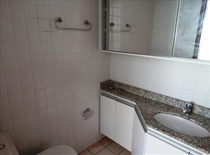 Banheiro com bancada e armários 