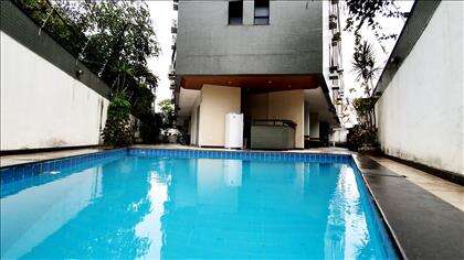 Piscina e churrasqueira ao fundo