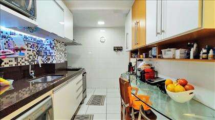 Cozinha com bancada, armários e iluminação