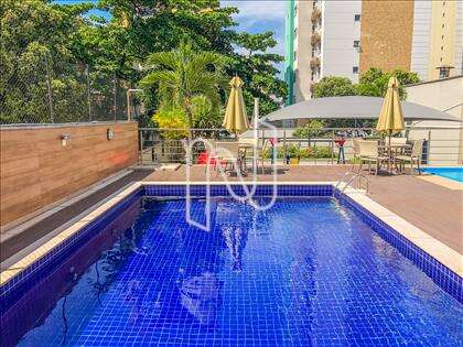 Piscina adulto com mesas, cadeiras e chaises