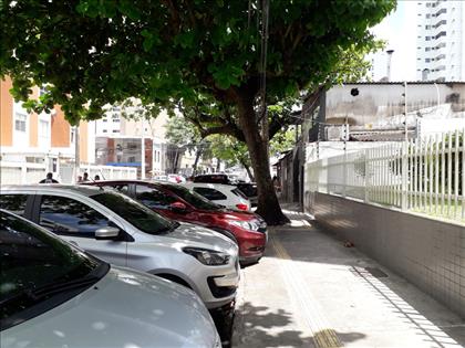 vista rua com estacionamento porta do prédio